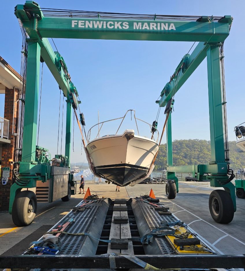 Marina crane loading boat onto trailer